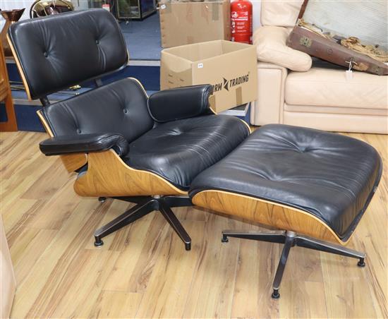 An Eames-style black leather armchair and footstool